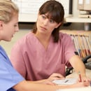 Physician reviewing standards with a newly hired nurse Physician reviewing standards with a newly hired nurse