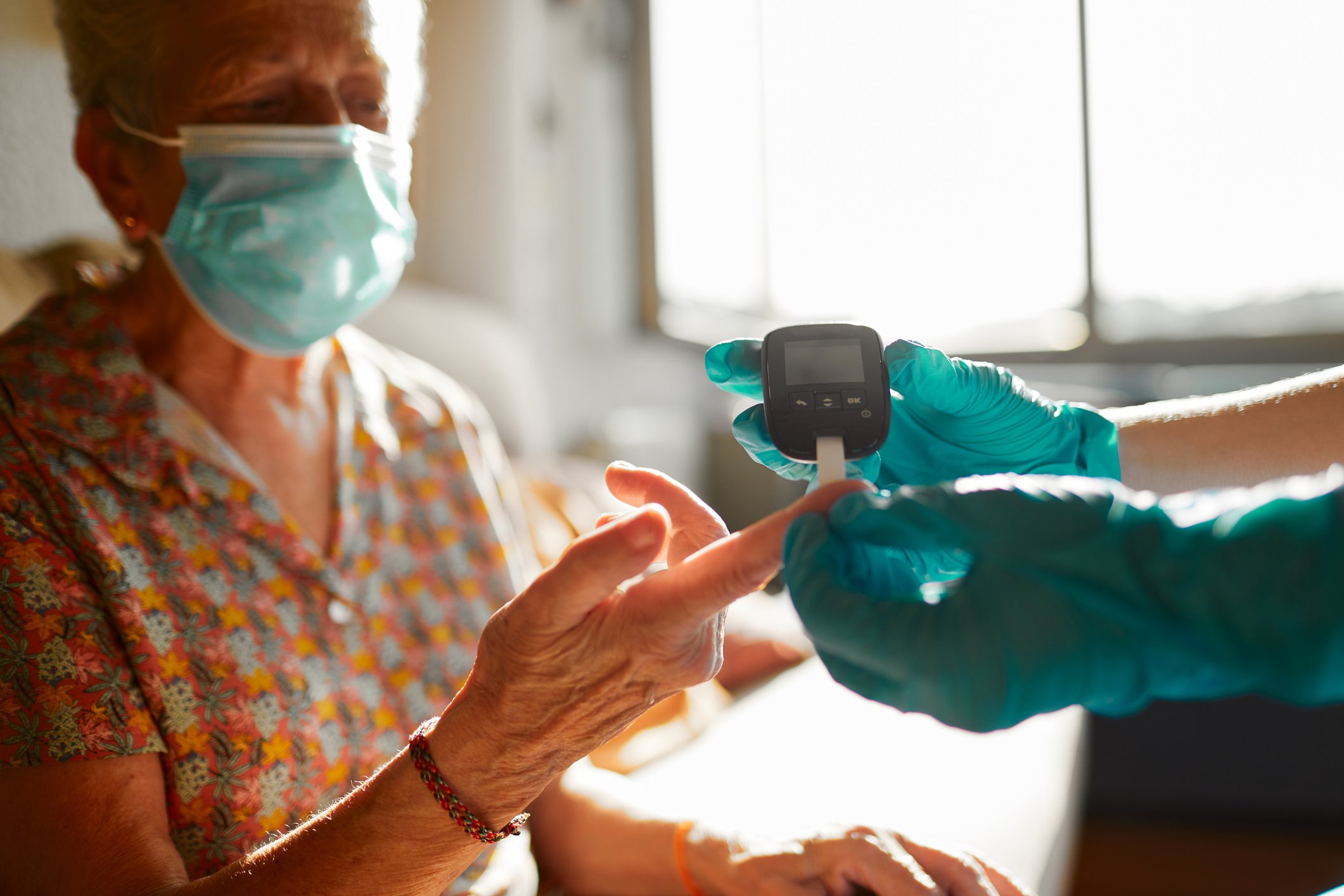 Nurse monitoring a diabetic patients' blood glucose Nurse monitoring a diabetic patients' blood glucose