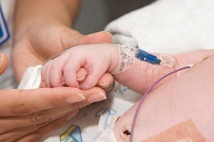 Nurse holding a newborn's hand Nurse holding a newborn's hand