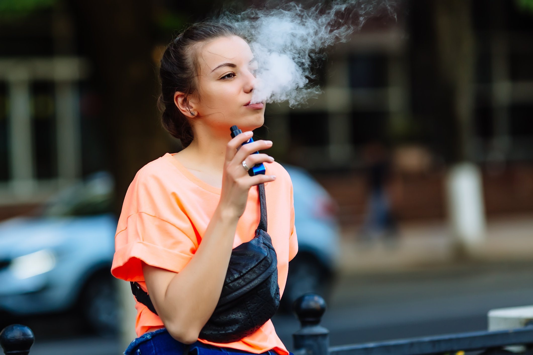 Teen blowing smoke out of a JUUL Teen blowing smoke out of a JUUL