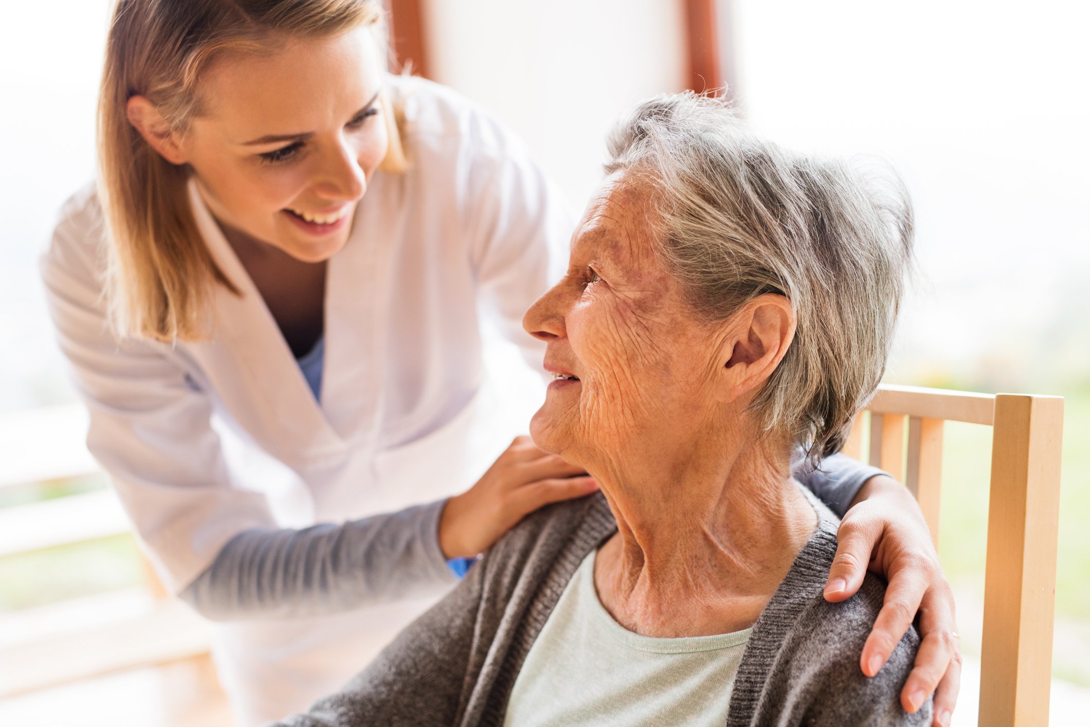 Geriatric nurse comforting an elderly patient Geriatric nurse comforting an elderly patient