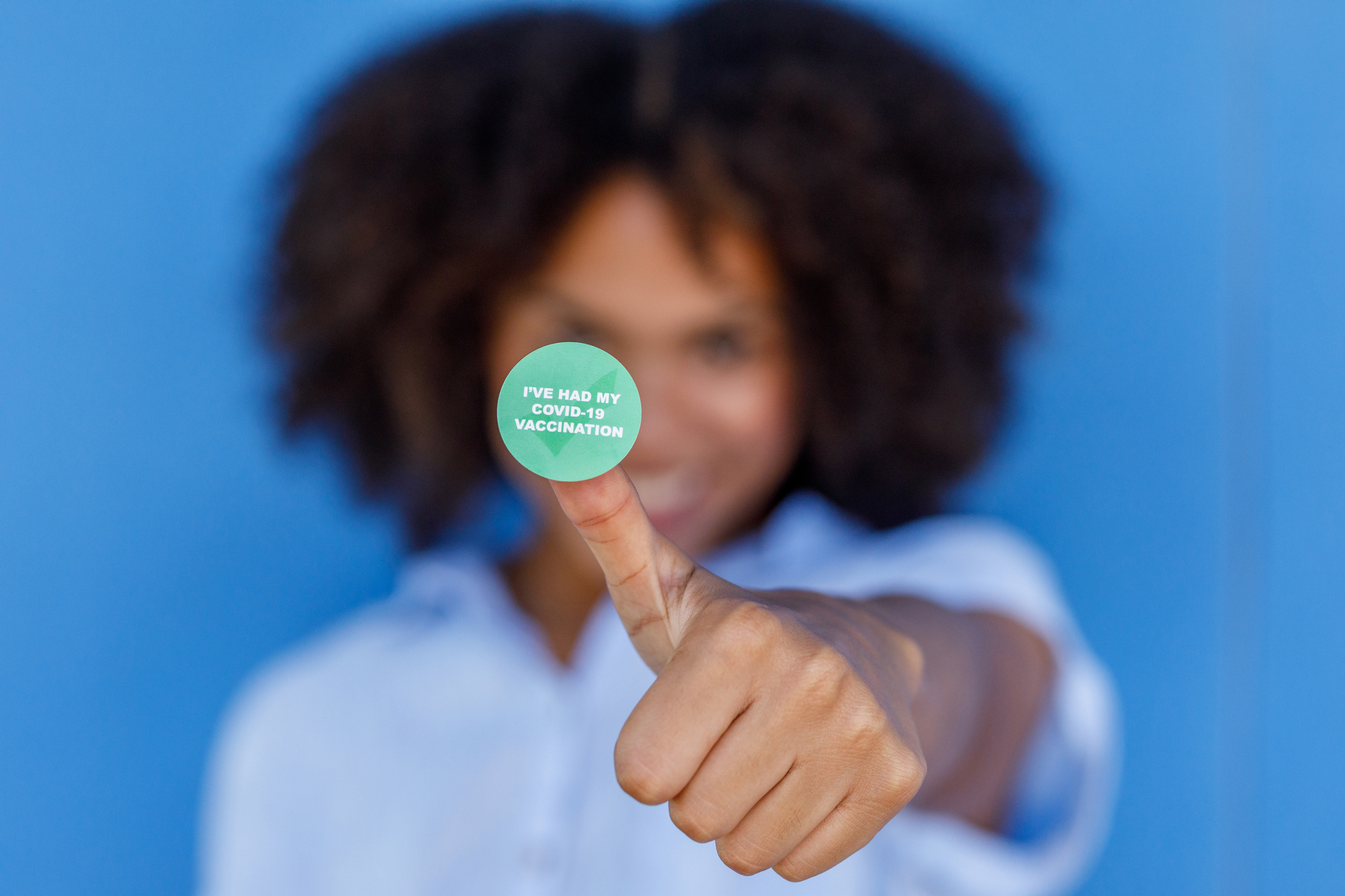 Woman showing off her vaccination sticker Woman showing off her vaccination sticker