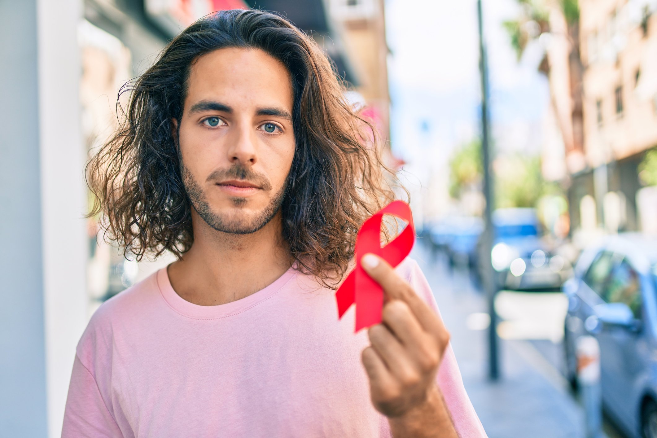 Man holding a red HIV ribbon Man holding a red HIV ribbon