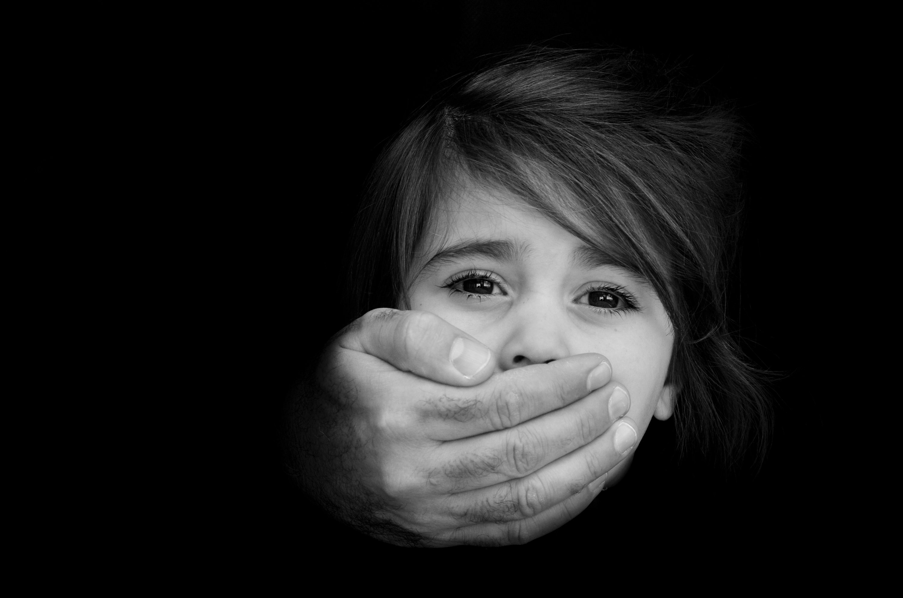 Child's mouth covered by a hand Child's mouth covered by a hand