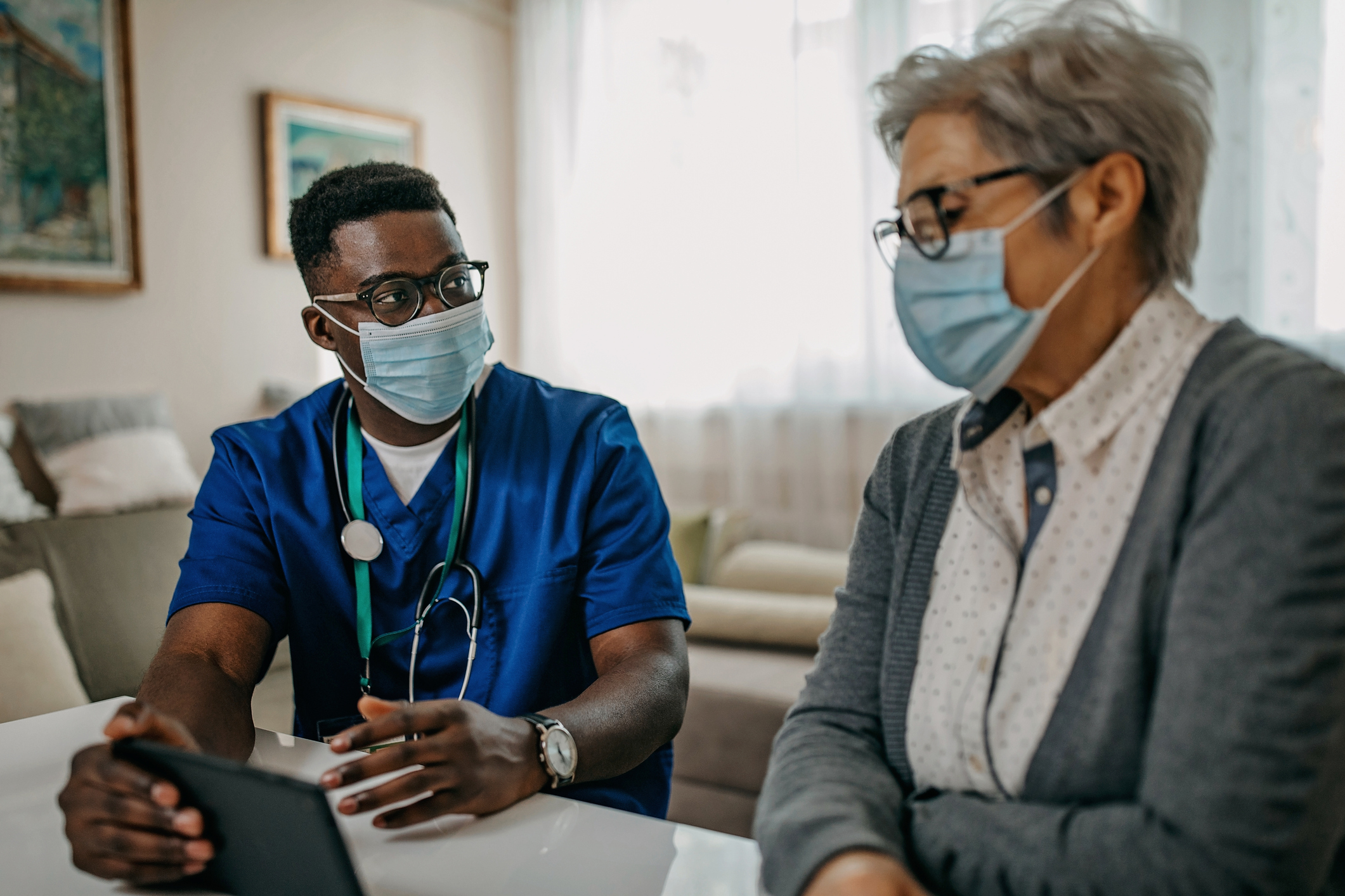 Nurse talking to a patient with masks on Nurse talking to a patient with masks on