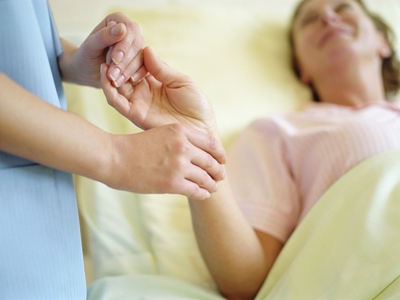 Nurse checking a patient's pulse Nurse checking a patient's pulse