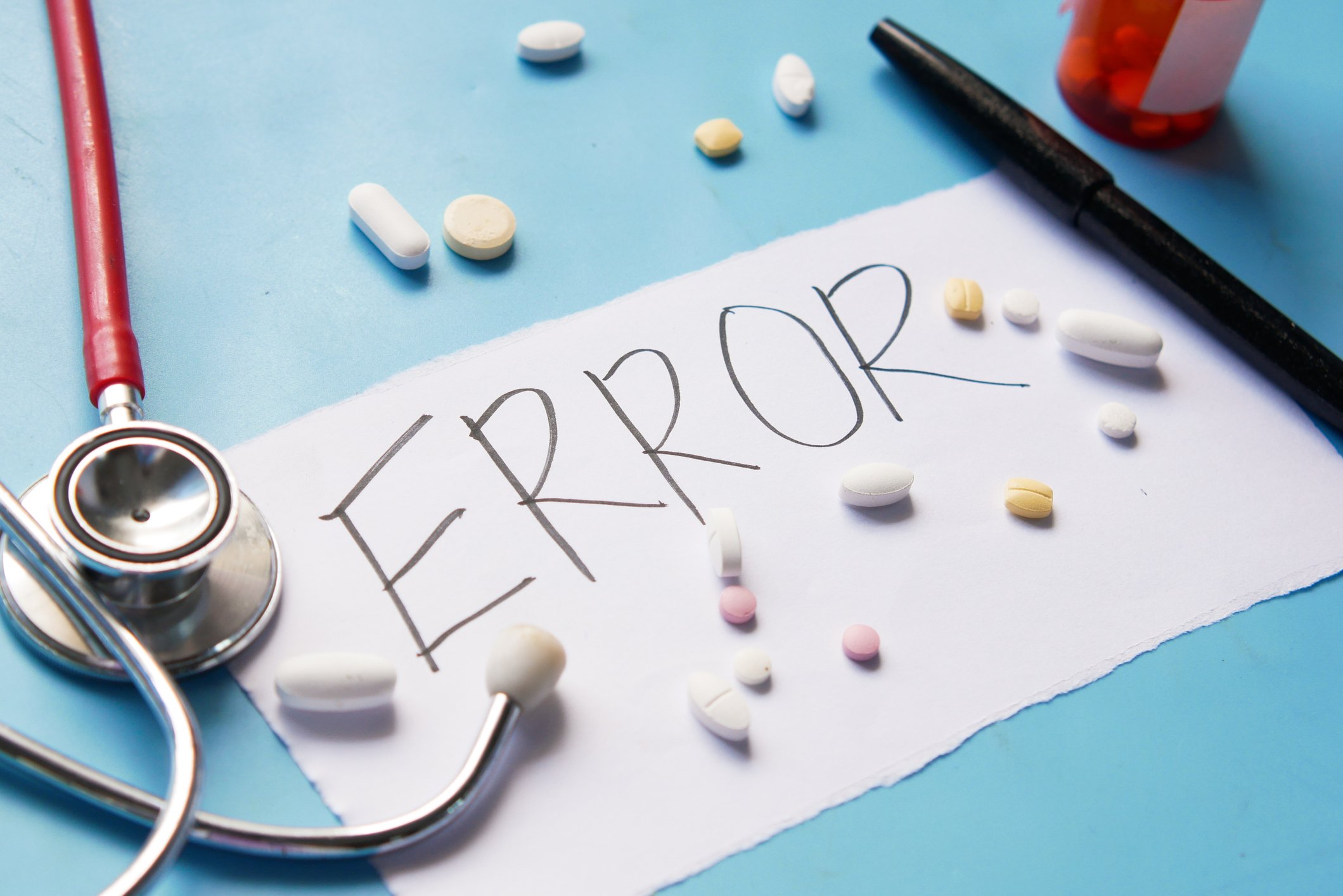 written 'error' message surrounded by medication pills and stethoscope written 'error' message surrounded by medication pills and stethoscope