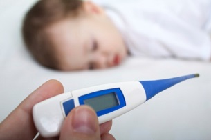 hand hold digital thermometer with patient in background hand hold digital thermometer with patient in background