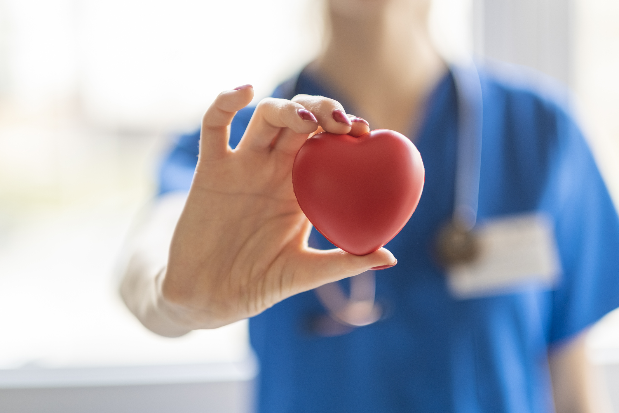 Nurse holding a red heart in her hand Nurse holding a red heart in her hand