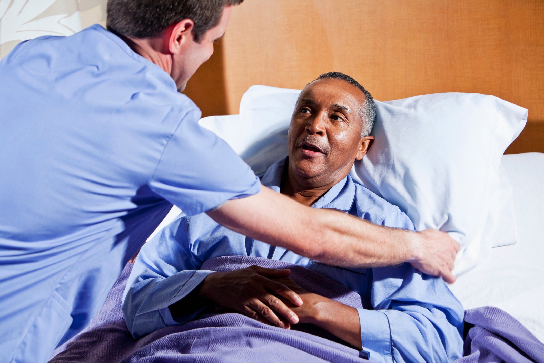 Clinician adjusting a patient in bed Clinician adjusting a patient in bed