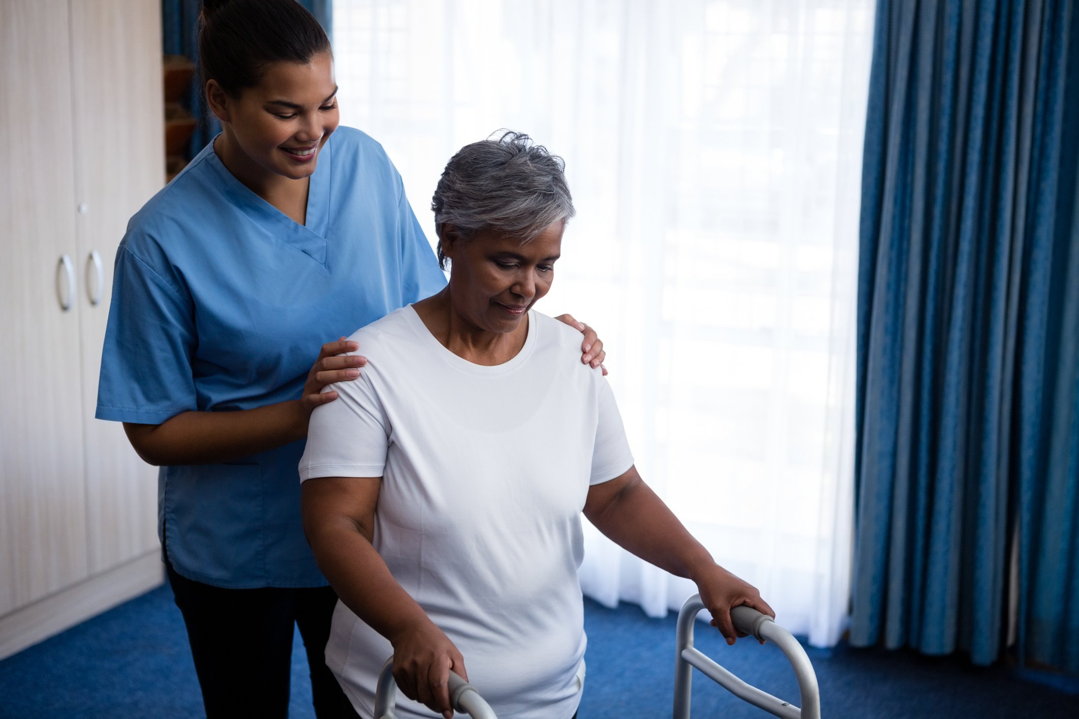 CNA helping a patient with a walker CNA helping a patient with a walker
